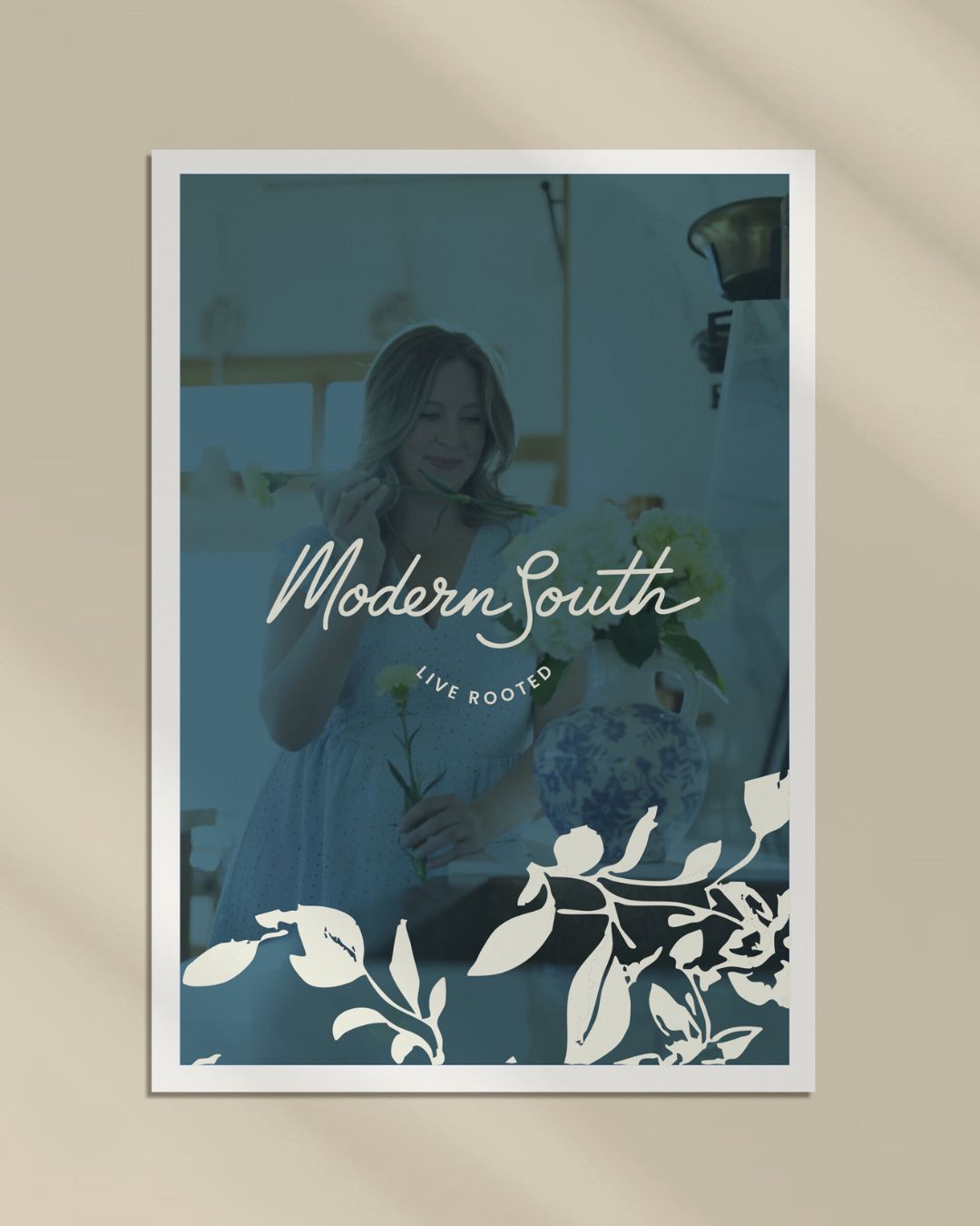 Photograph of Kellie Walton holding flowers with a honeysuckle pattern along the bottom of her photo and her logo with the words "Modern South Live Rooted".