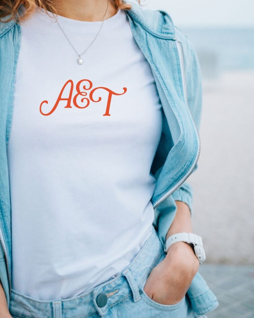 Minimalist logo printed on a soft, neutral-toned branded t-shirt.