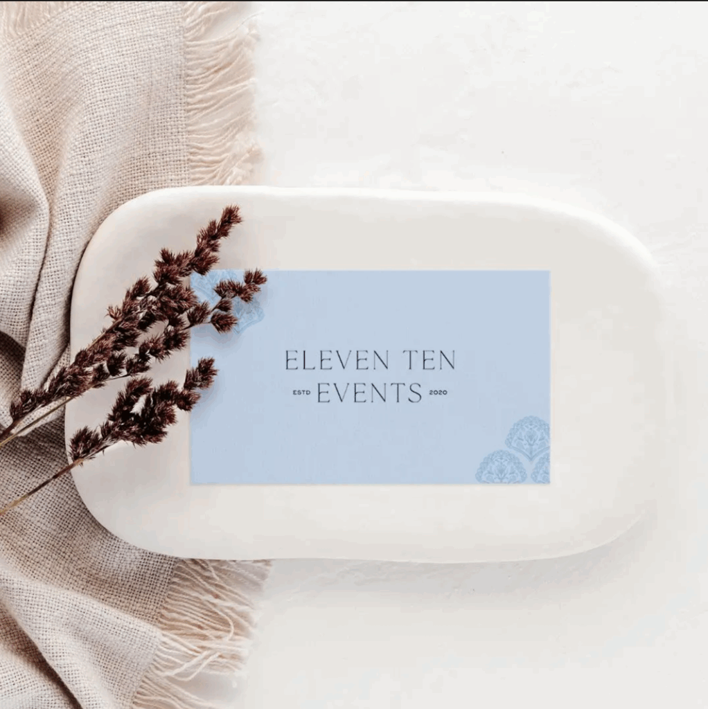 Blue branded business card with a delicate pattern in the corner and the words "Eleven Ten Events"
