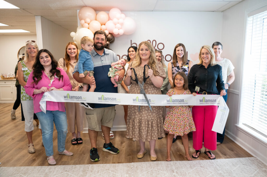Makena cutting the ribbon at the ribbon cutting ceremony at Hello Motherhood.
