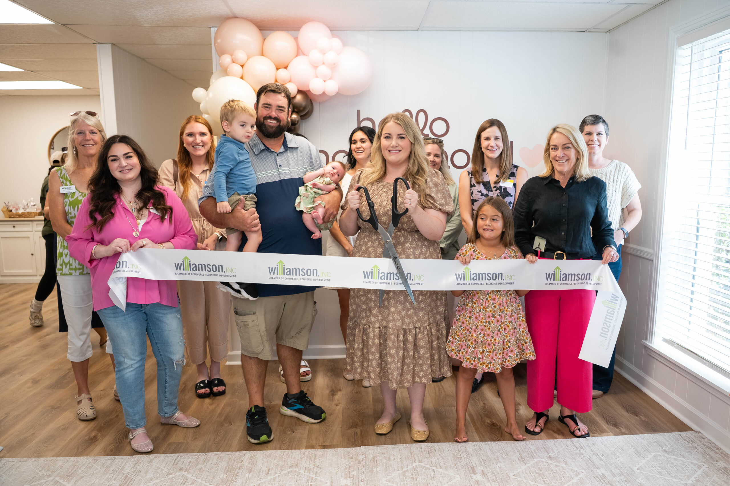 Makena cutting the ribbon at the ribbon cutting ceremony at Hello Motherhood.